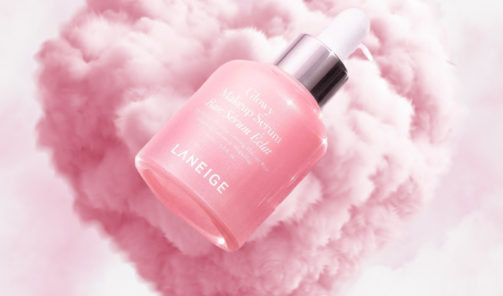 Laneige Glowy Makeup Serum floating in pink cloud heart background with soft luminous glow