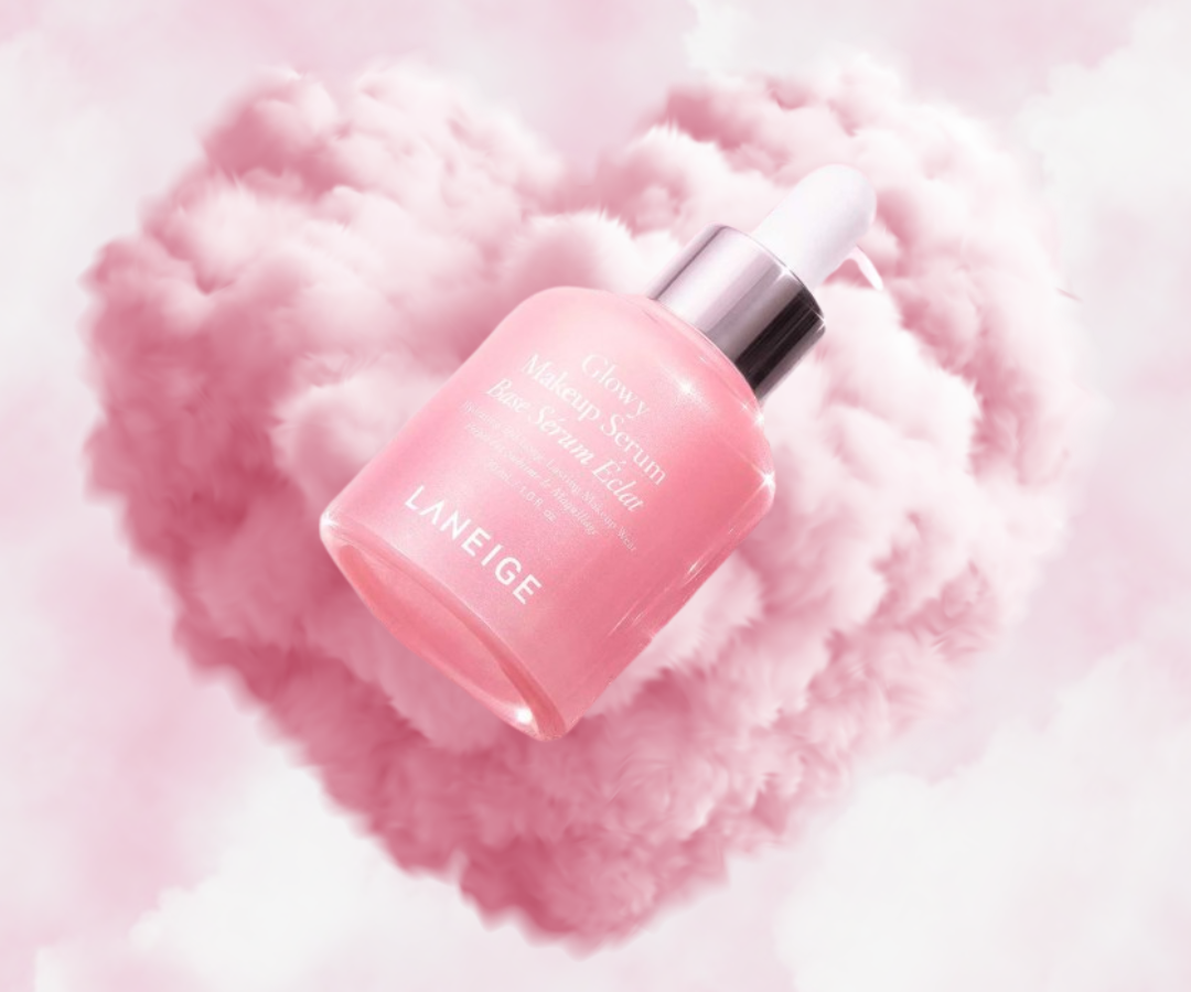 Laneige Glowy Makeup Serum floating in pink cloud heart background with soft luminous glow
