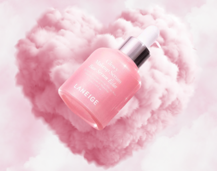 Laneige Glowy Makeup Serum floating in pink cloud heart background with soft luminous glow